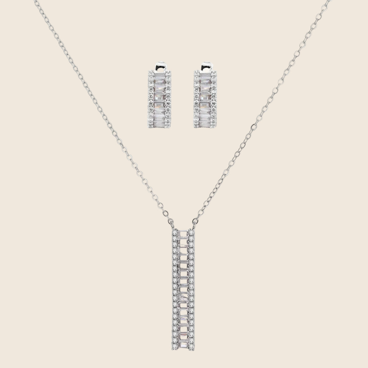 White gold plated necklace with vertical cubic zirconia pendant and matching hoop earrings on neutral background