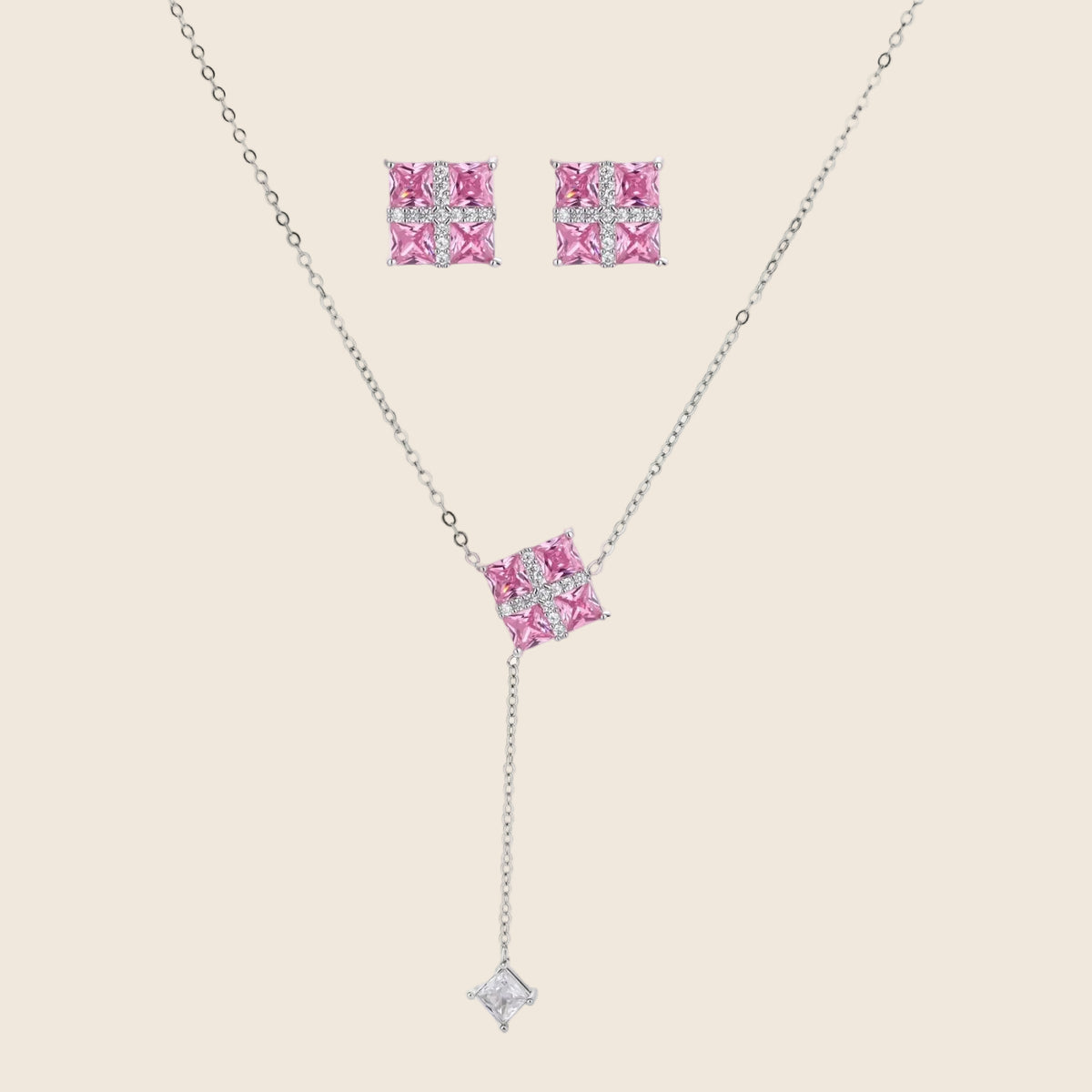 White gold plated jewelry set with pink cubic zirconia stones in geometric cross design, featuring Y-necklace and square stud earrings