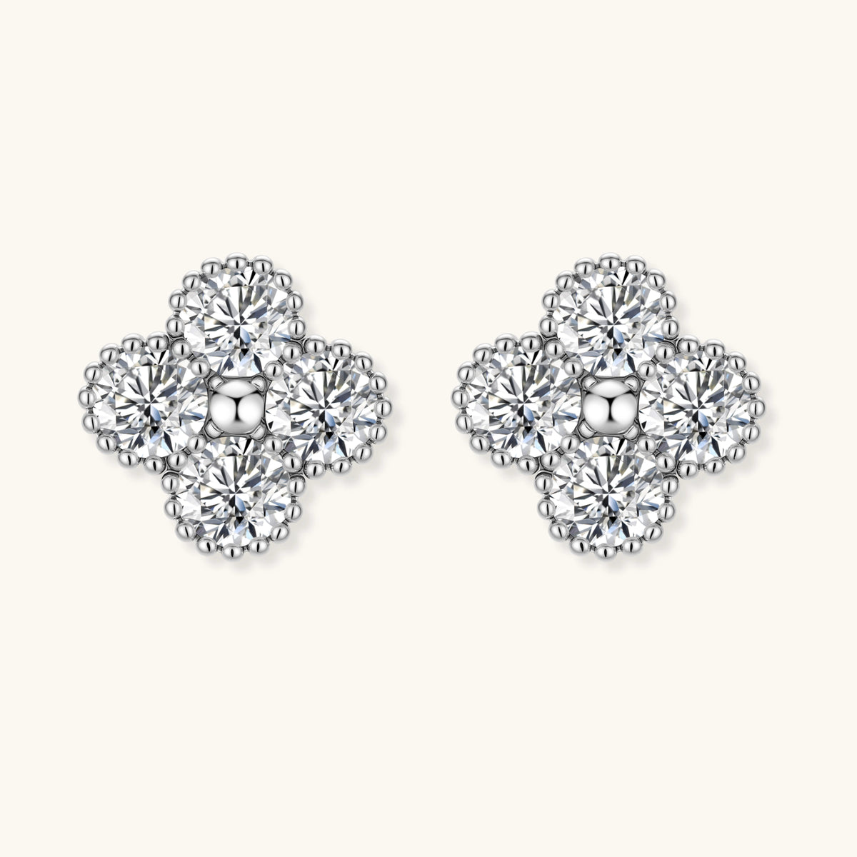 Dainty sterling silver quatrefoil stud earrings with four brilliant moissanite stones and center accent on white background.