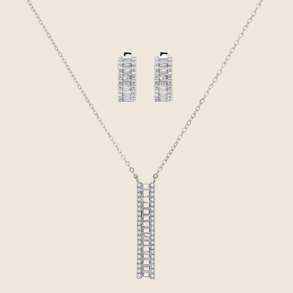 White gold plated necklace with vertical cubic zirconia pendant and matching hoop earrings on neutral background