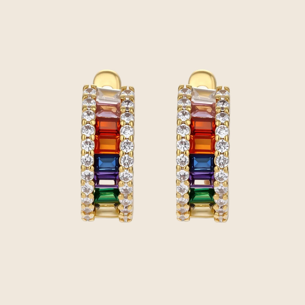 Gold-plated jewelry set featuring rainbow baguette-cut cubic zirconia stones in geometric design on cream background