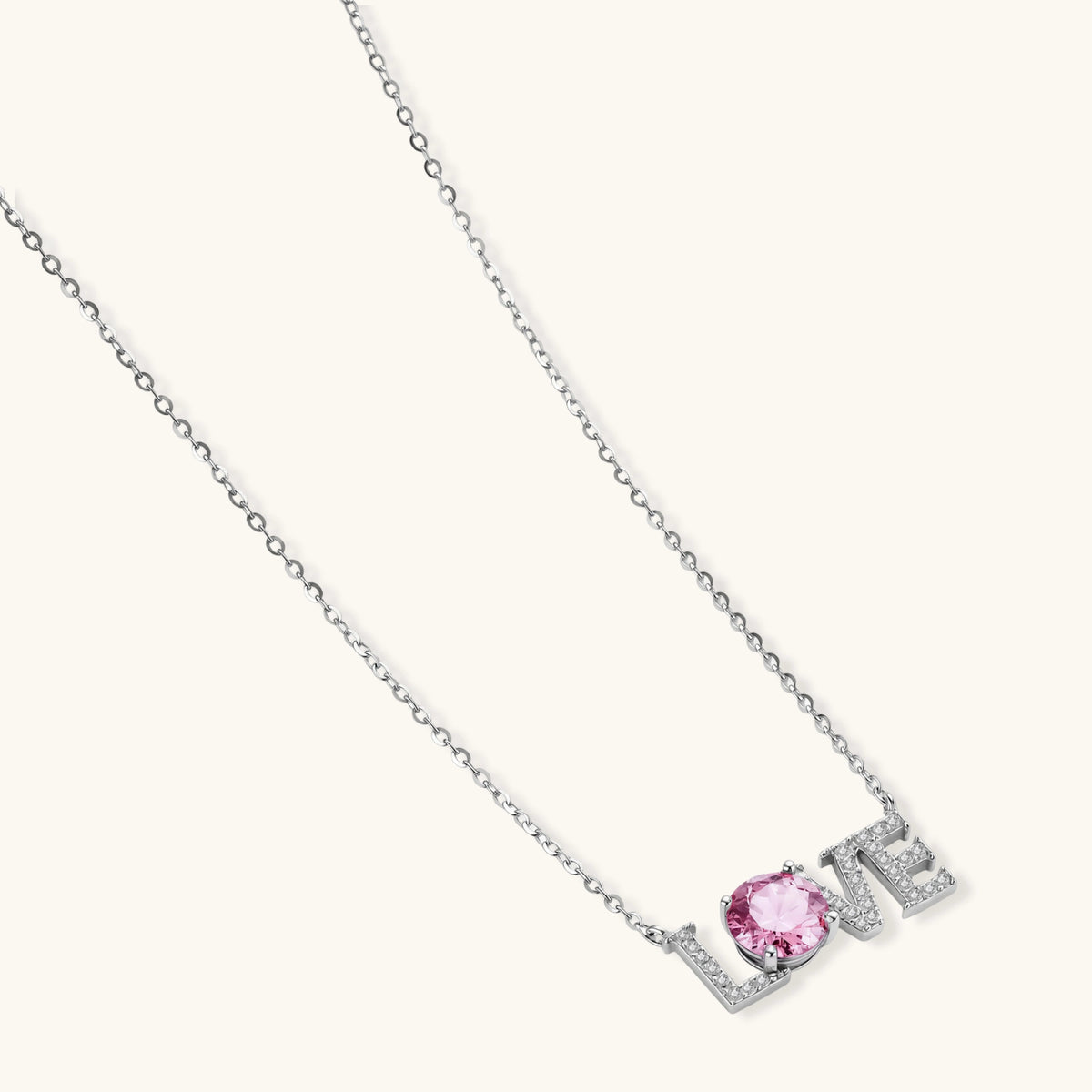Sterling silver LOVE necklace with pink moissanite stone replacing the O, featuring crystal-set letters on delicate chain.