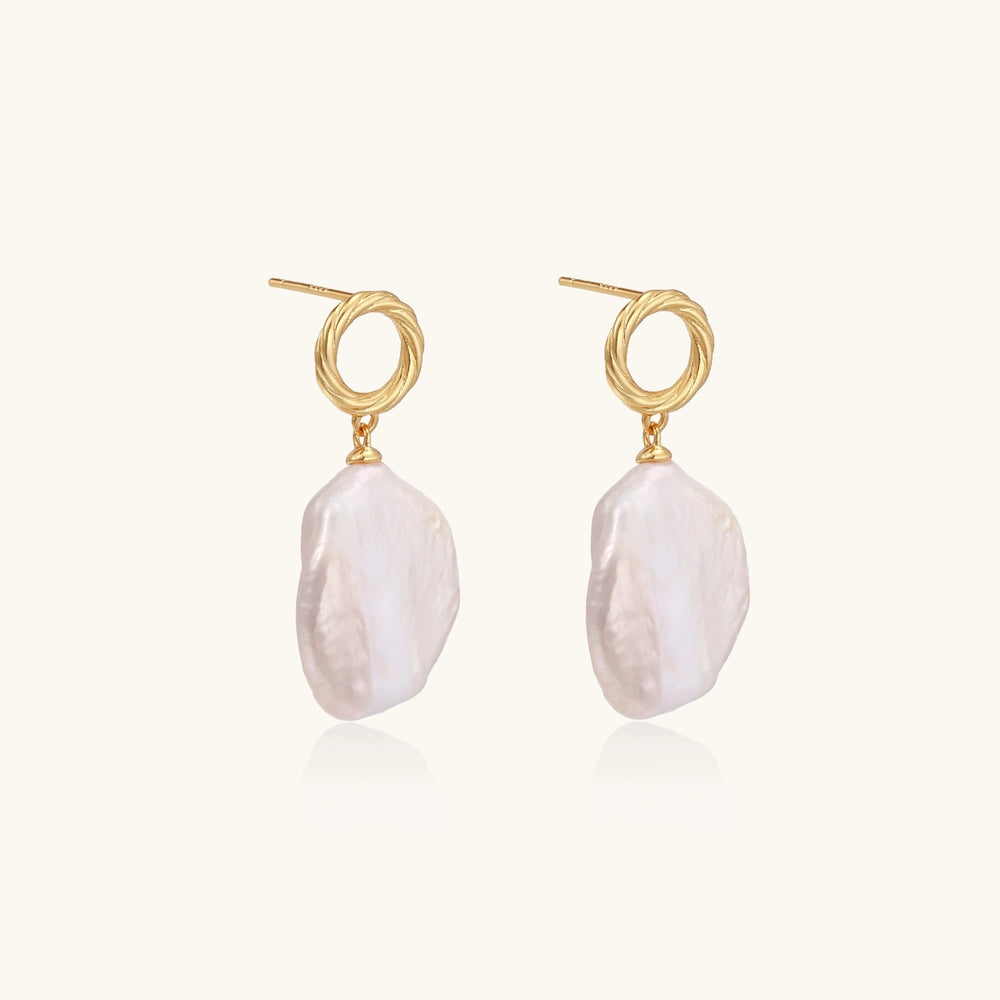 18K gold vermeil twisted circle studs with organic white baroque pearl drops on cream background