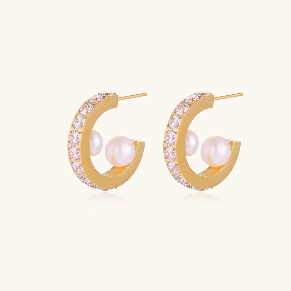 Gold pavé hoop earrings with two freshwater pearls nestled inside the curved design, featuring crystal-studded outer edge.