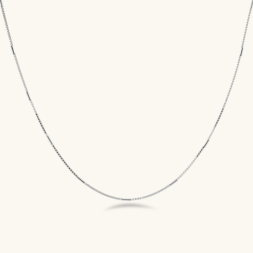 Delicate platinum-plated sterling silver necklace with alternating textured cubic links and smooth chain sections.