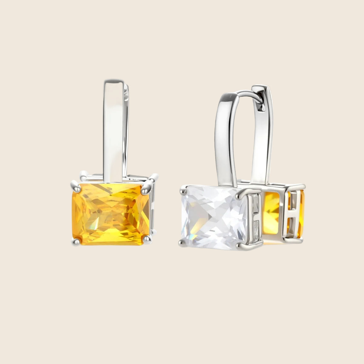 Silver curb-chain necklace and hoop drop earrings set with paired yellow and clear square zirconia stones.