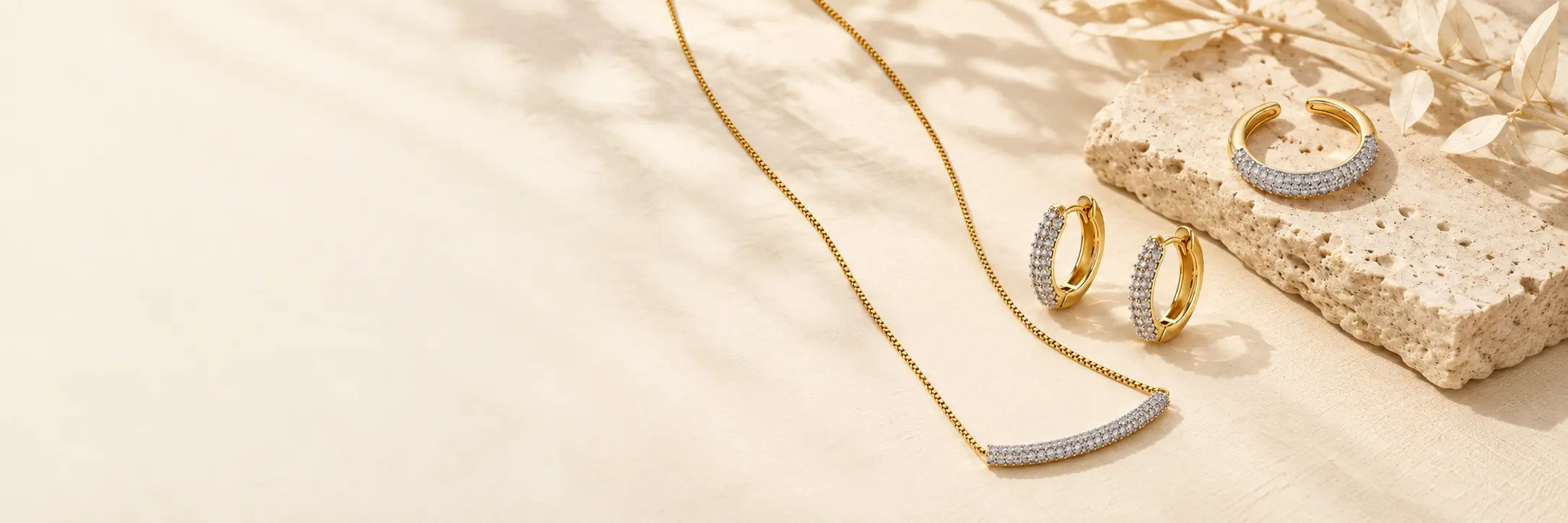 Lunara necklace, hoop earrings and open ring on ivory linen and travertine